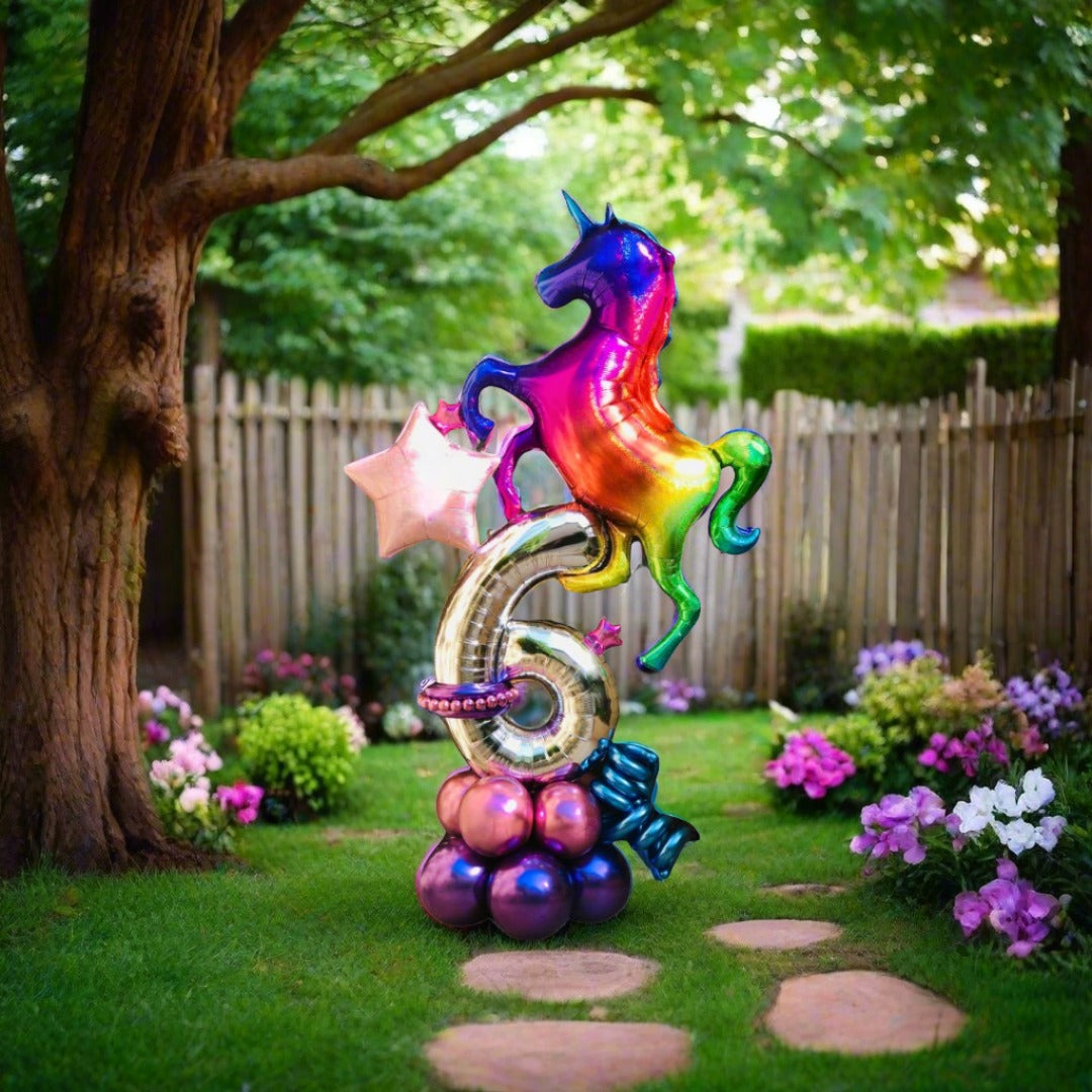 Colorful unicorn-themed balloon arrangement with rainbow accents and a custom number.