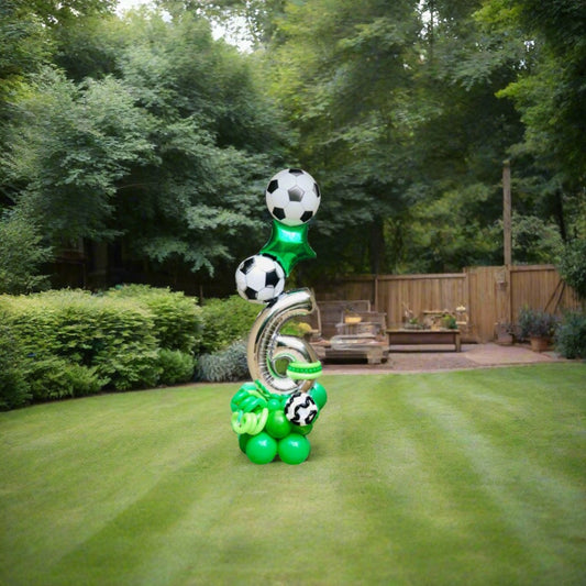 Soccer-themed balloon display featuring soccer balls and a green star balloon, perfect for birthday celebrations.